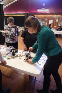 STLS Staff Member Alex demonstrates how the Button Maker works at the STLS Annual Meeting.
